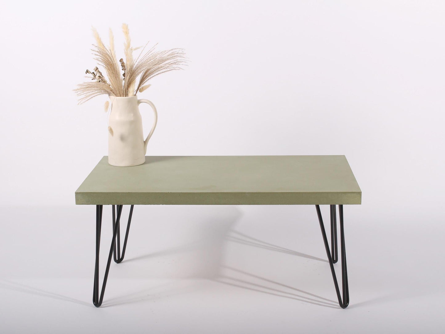 Large green concrete coffee table with hairpin legs