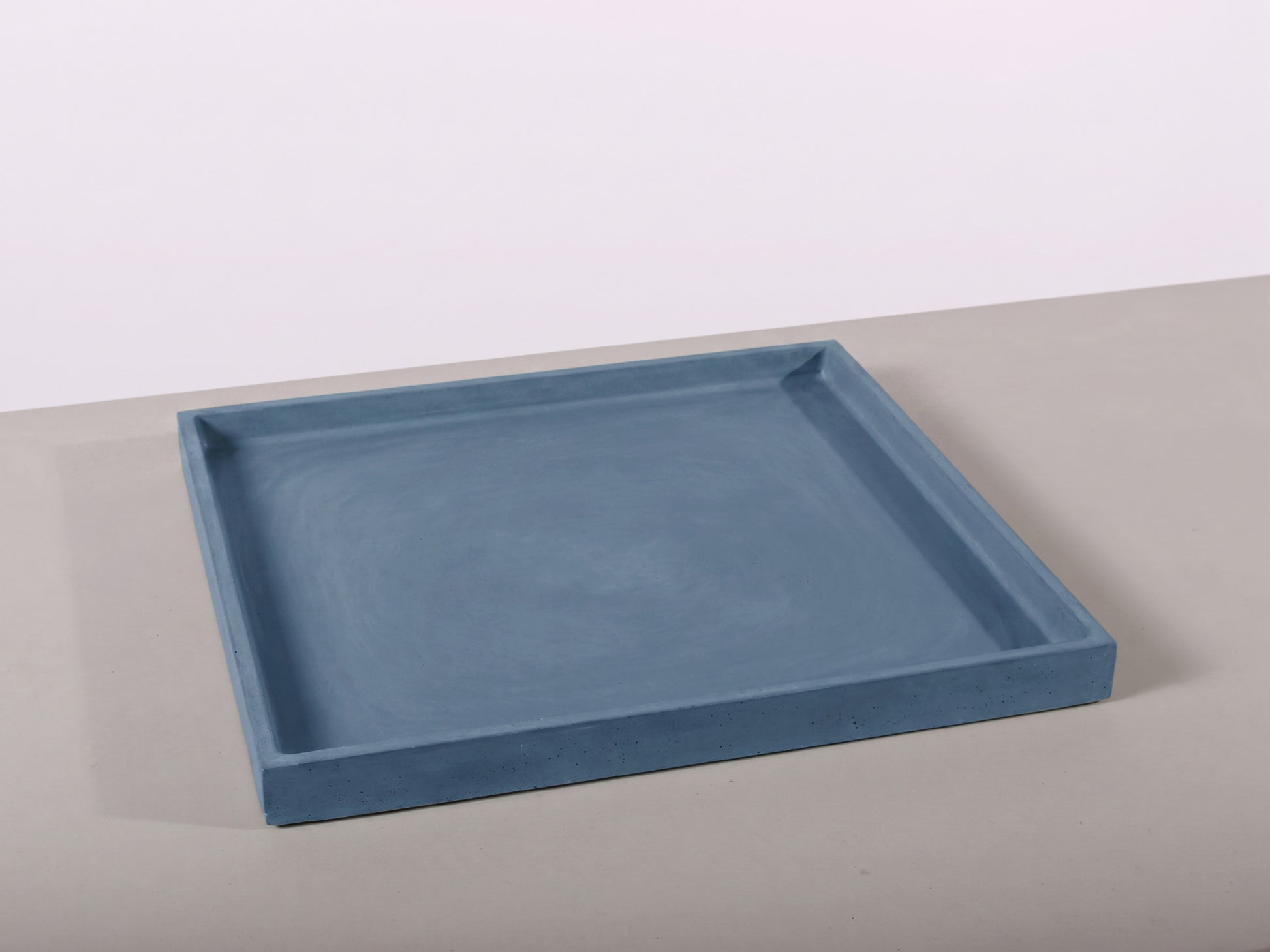 Blue rectangular tray on a light gray surface with a white background