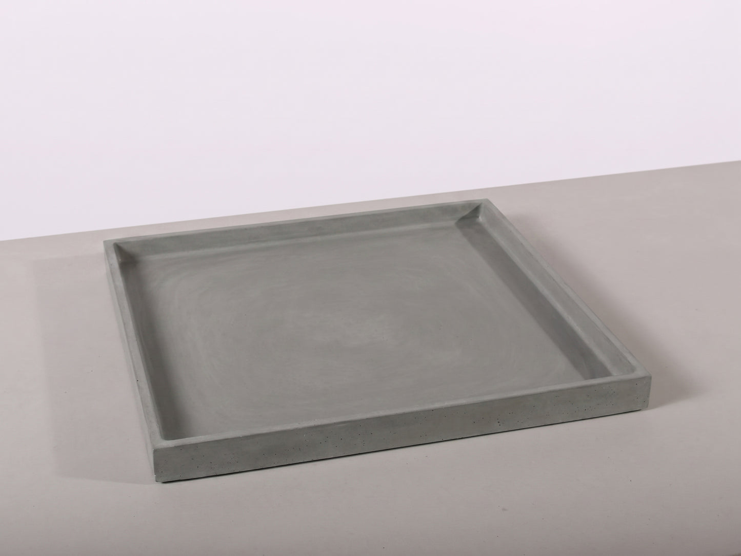 Gray rectangular tray on a light gray surface with a white background