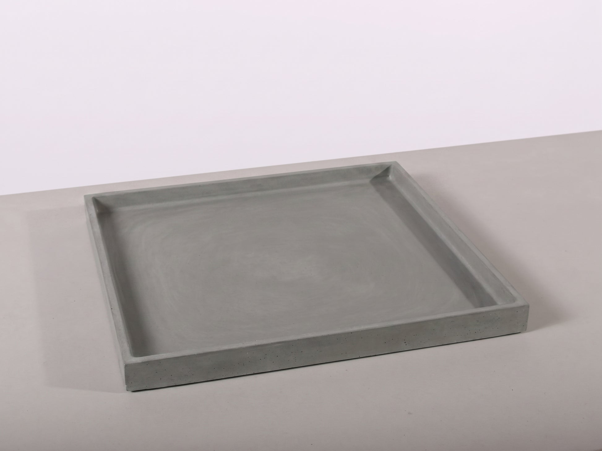 Gray rectangular tray on a light gray surface with a white background