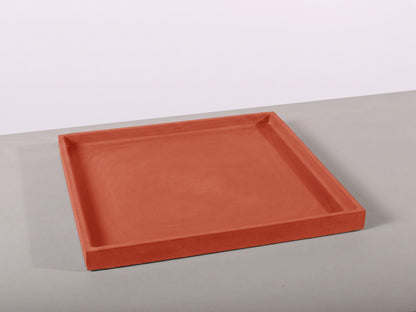 Terracotta-colored tray on a light gray surface with a white background