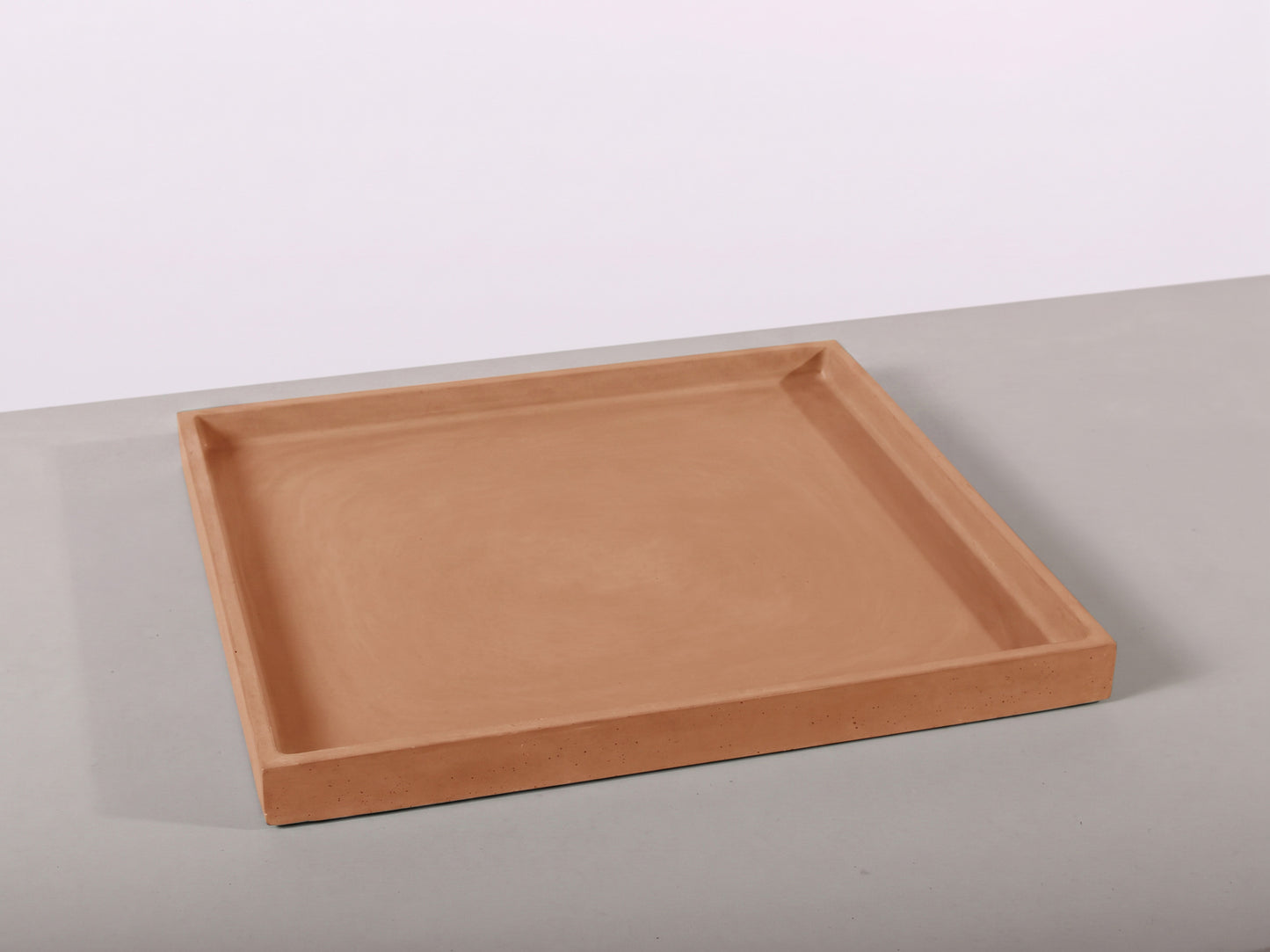 terracotta rectangular tray on a light gray surface with a white background