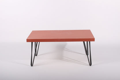 Red table with black hairpin legs on a white background