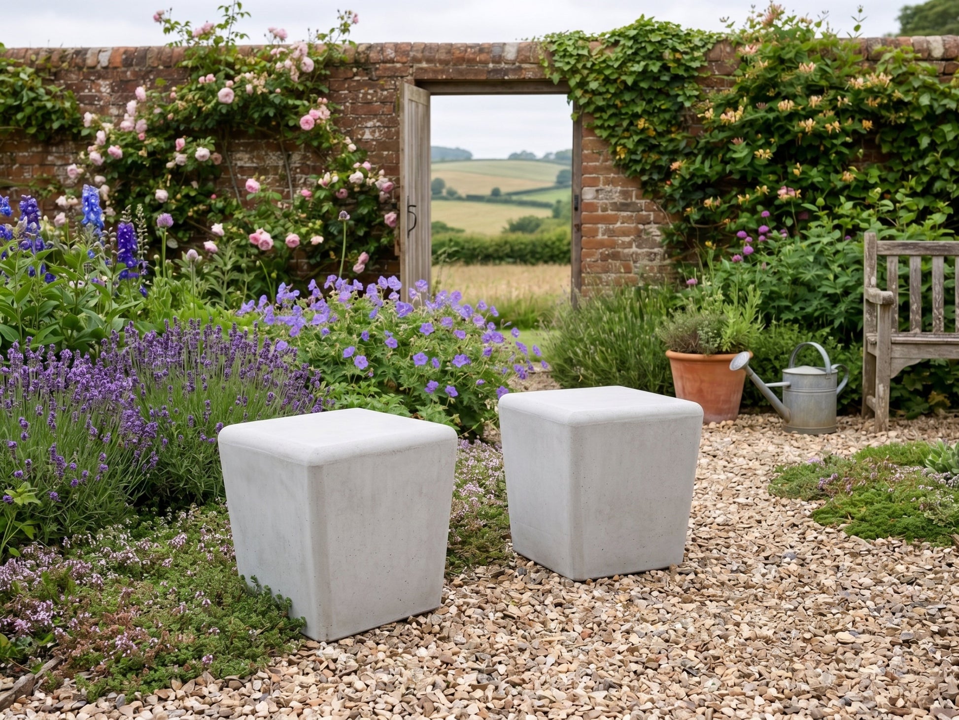 Two concrete cube-shaped stools in a garden with flowers and a bench.