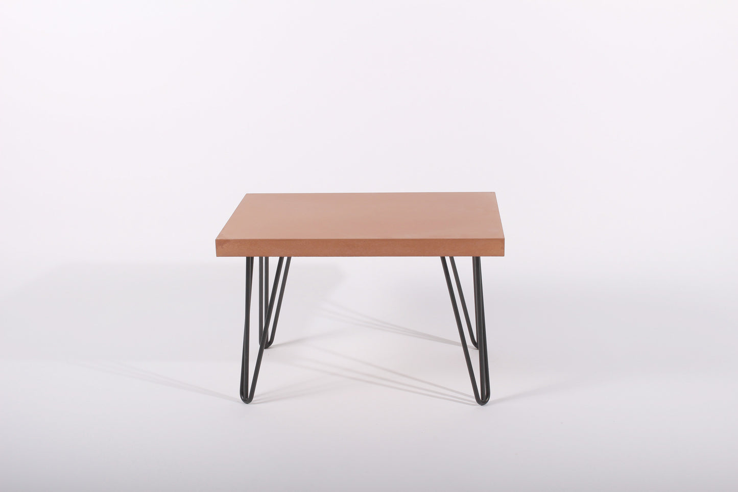 Small terracotta table with black metal legs on a white background