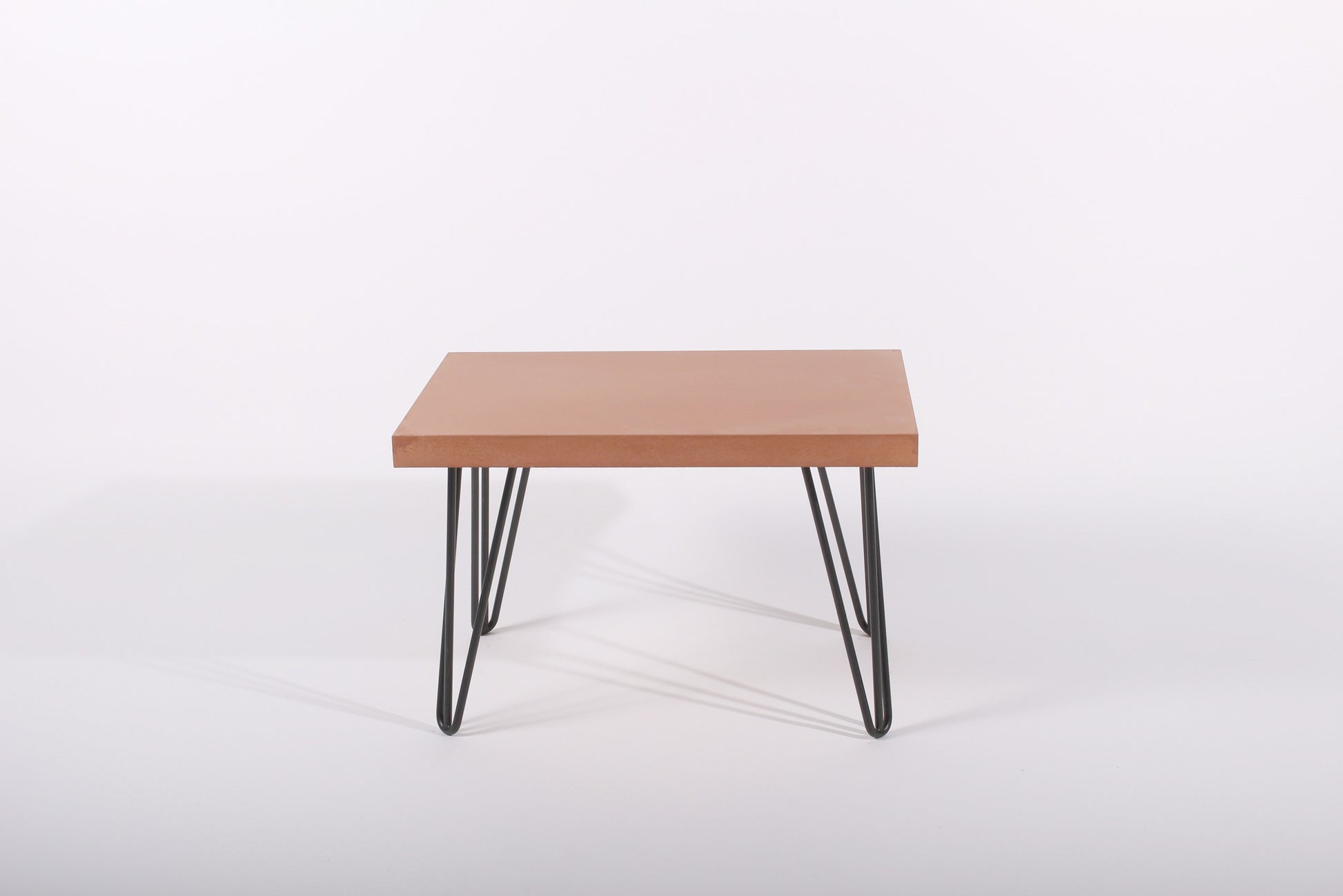 Small terracotta table with black metal legs on a white background
