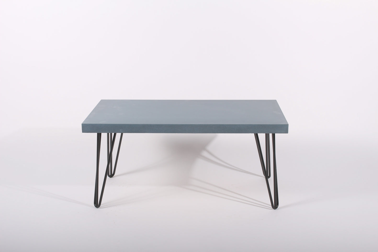 Lagoon blue table with black hairpin legs on a white background
