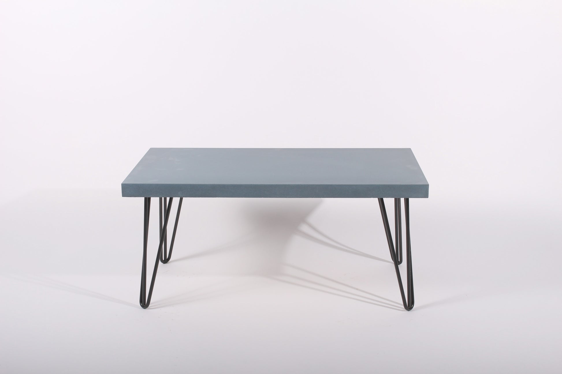 Lagoon blue table with black hairpin legs on a white background