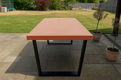 Outdoor table with a red top and black legs on a patio