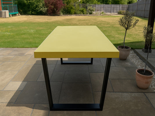 Yellow outdoor table with black legs on a patio