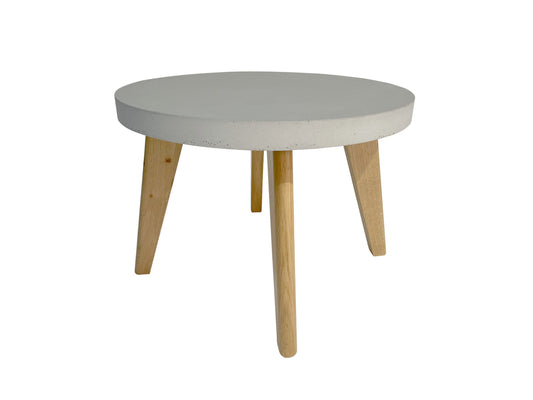 Round coffee table with a white top and wooden legs on a white background