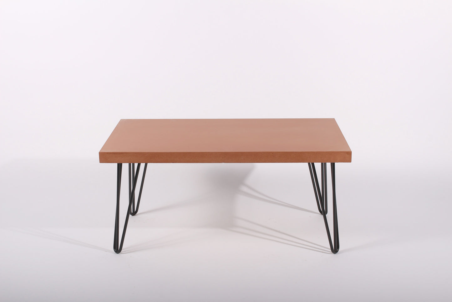 terracotta table with black hairpin legs on a white background