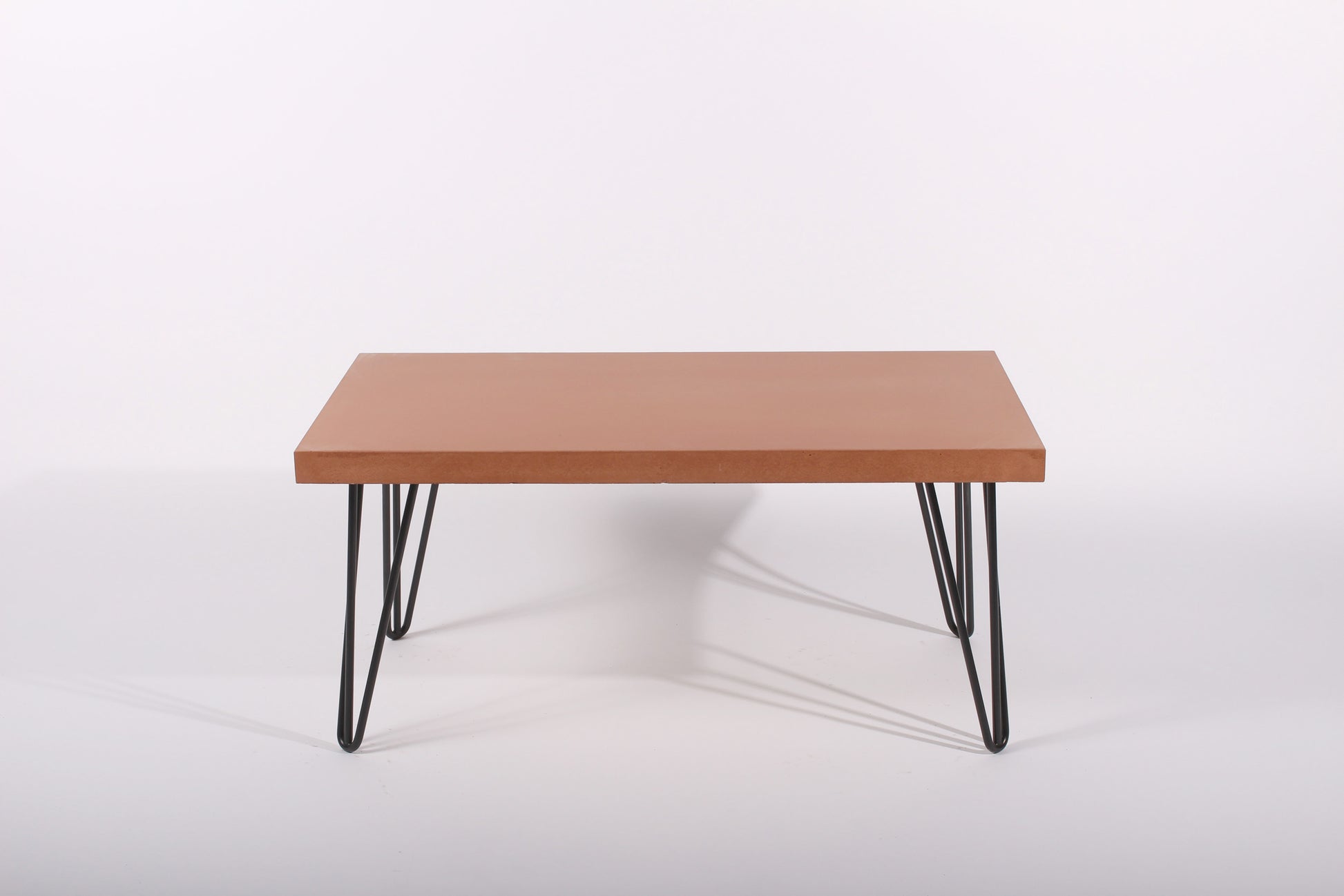 terracotta table with black hairpin legs on a white background